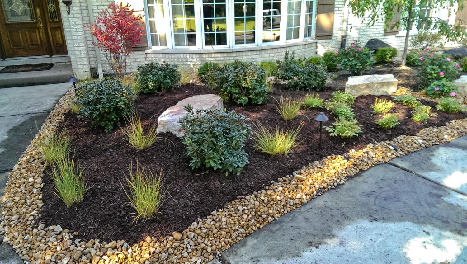 Front yard landscape featuring a mulched garden bed in Hudson